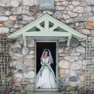 bride with floral bouquet standing at Willowdale Green doorway just outside Boston, Massachusetts