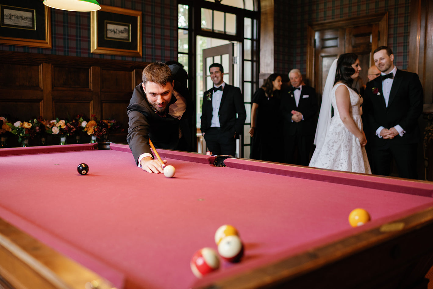 Groomsmen playing pool in library at Tupper Manor on North Shore