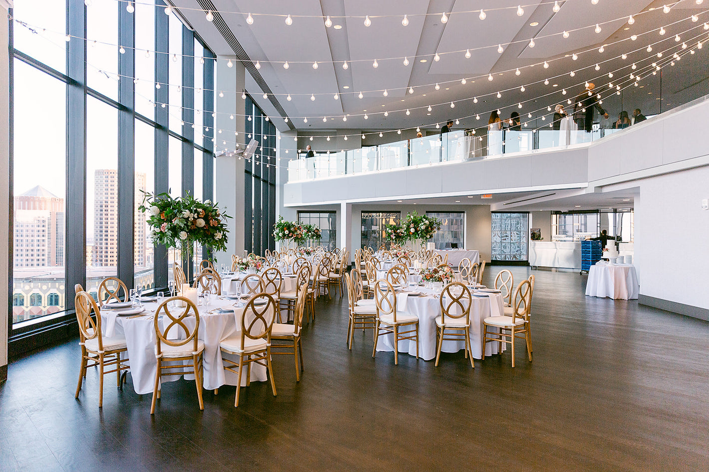 Wedding reception with bistro lighting and tablestop rentals at the state room in Boston