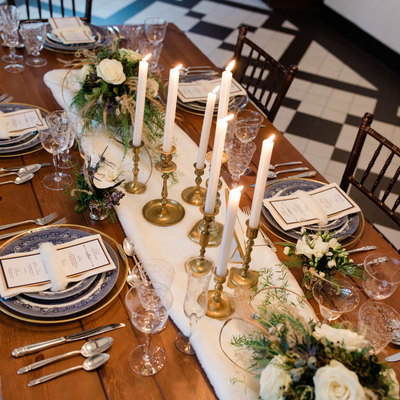Wedding reception table set with tabletop event rentals including brass candlesticks with winter theme at Willowdale Estate just outside Boston Massachusetts
