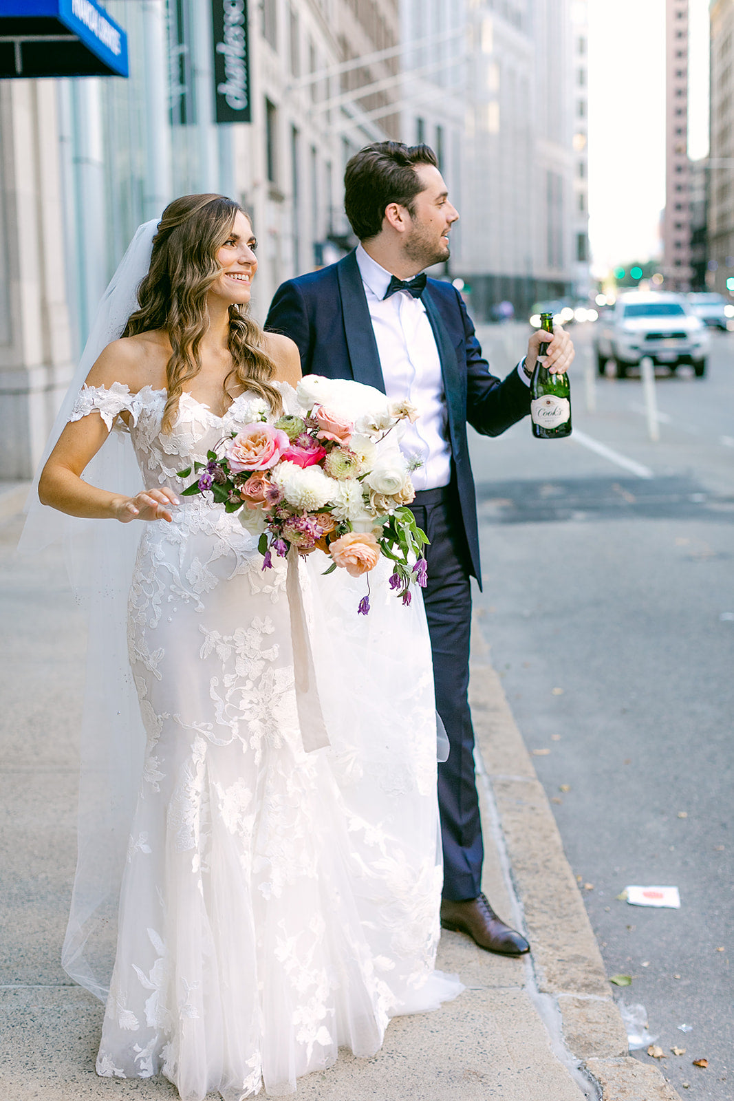 bride and groom walking the street of boston in wedding dress and suit