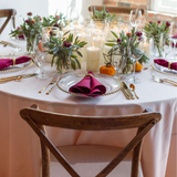Decorated table with autumn-themed centerpieces burgundy linen and forged gold flatware rentals at wedding in Massachusetts, New England.