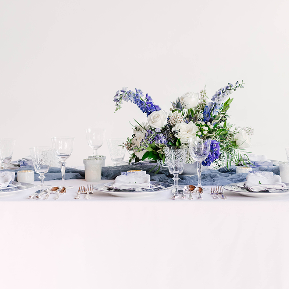 Gorgeous blue and white wedding tablescape set with blue willow dinnerware and blue dot charger plate at venue in MA.