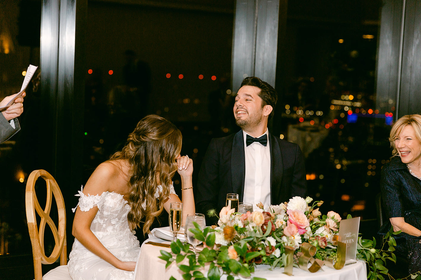 Wedding couple laughing at Groomsmen giving toast Boston Night Sky in background
