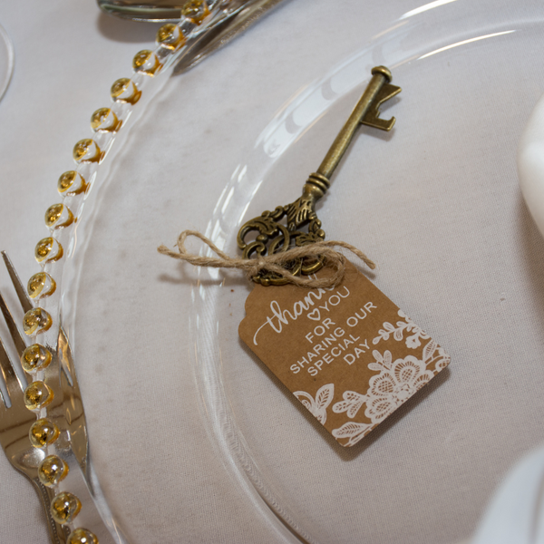 Gold beaded charger plate with key on top for place setting at an event